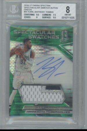 A graded basketball trading card featuring Karl-Anthony Towns. The card displays his autograph, a jersey swatch, and his image in a Timberwolves uniform. The grade is 8 (NM-MT) by Beckett.