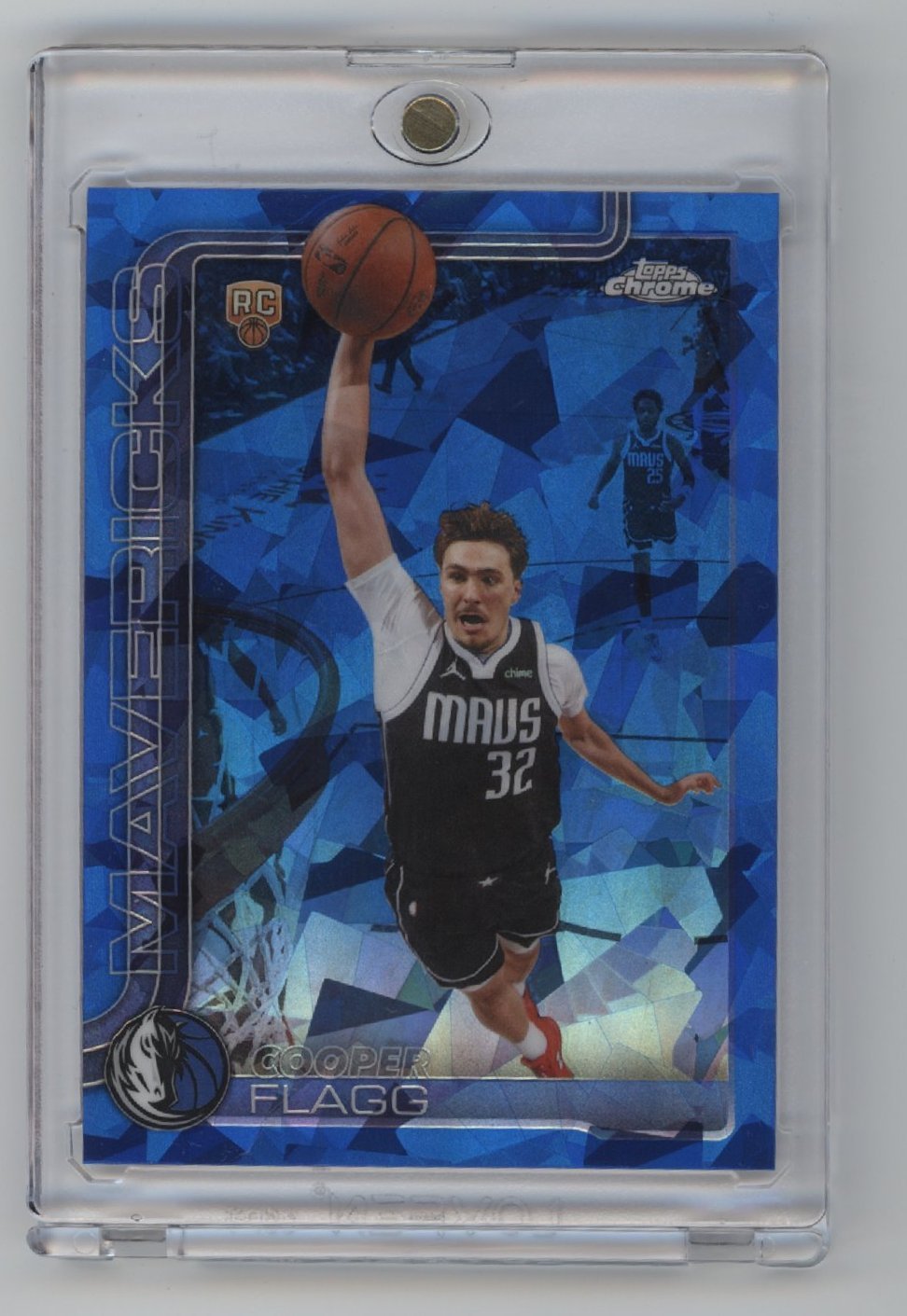 Basketball trading card featuring a player in a black MAVS jersey (#32), mid-air for a dunk, set against a blue geometric background. The card says MAVERICKS and COOPER FLAGG.
